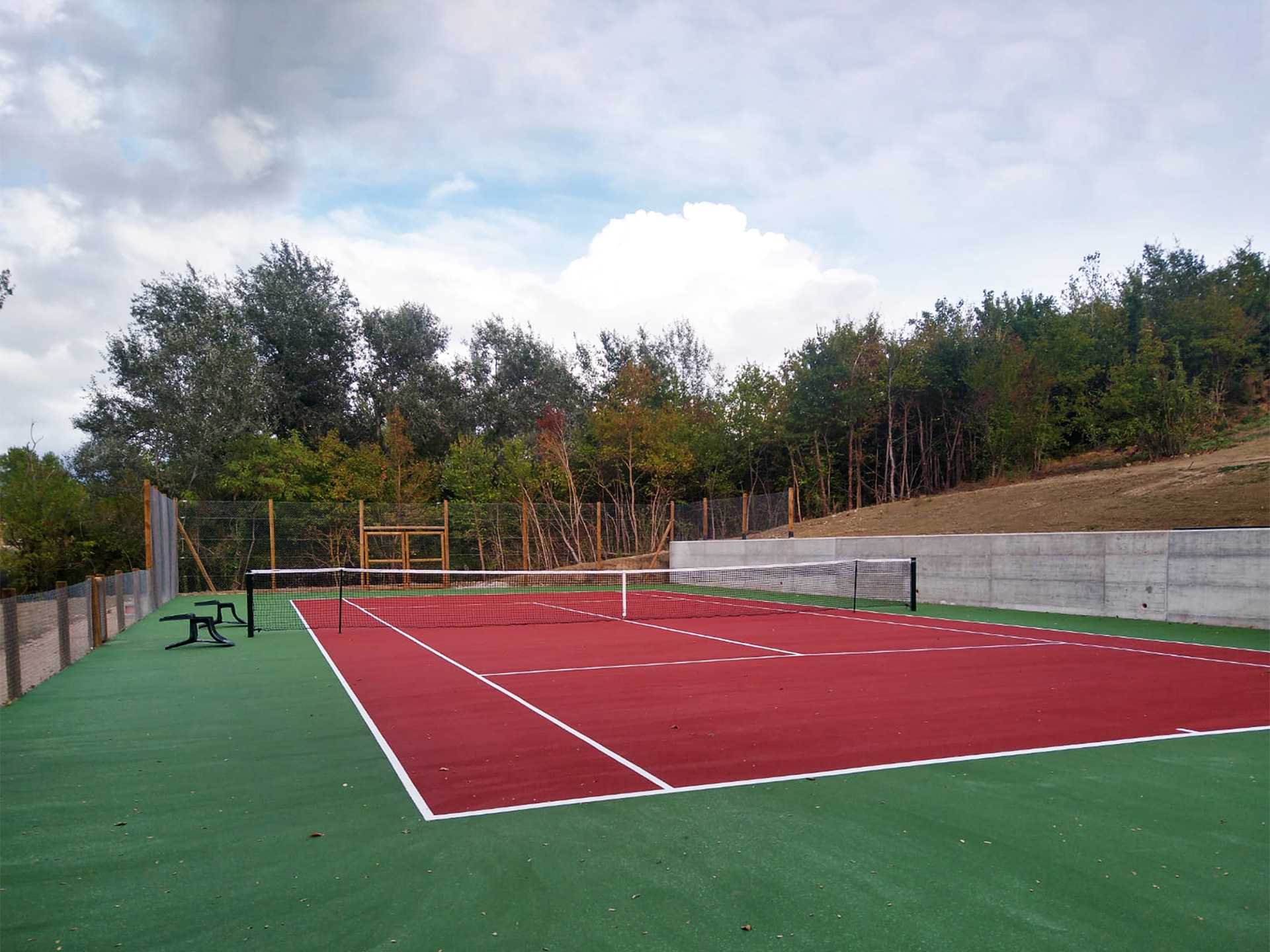 Campo da tennis inserito in un contesto paesaggistico.